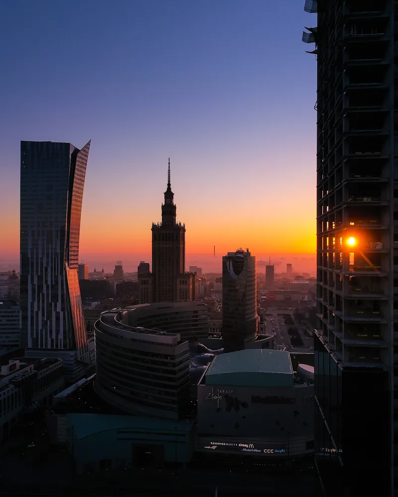 Panorama Warszawy o zachodzie widziana między budynkami